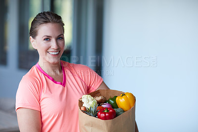Buy stock photo Portrait of a young attractive woman carrying a bag of groceries at home