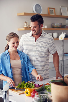 Buy stock photo Cropped shot of a married couple making food together in the kitchen at home