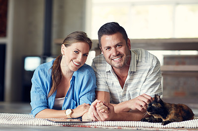 Buy stock photo Portrait of a young married couple spending the day with their pet at home