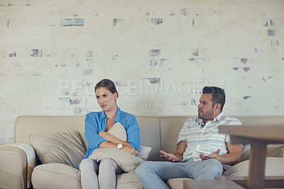 Buy stock photo Cropped shot of a young married couple having a disagreement in the living room at home