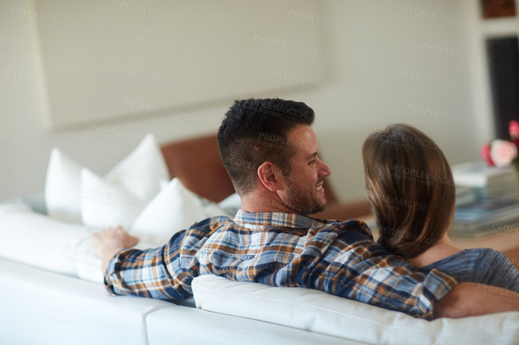 Buy stock photo Rearview shot of a young married couple spending the day at home