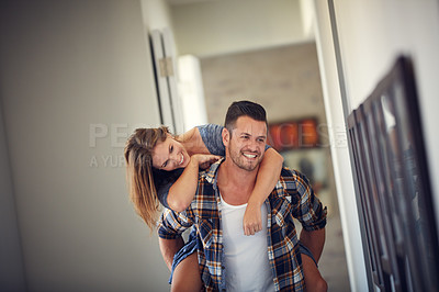 Buy stock photo Cropped shot of a young handsome man giving his beautiful wife a piggyback ride at home
