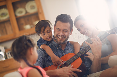 Buy stock photo Shot of a happy father playing the guitar for his family