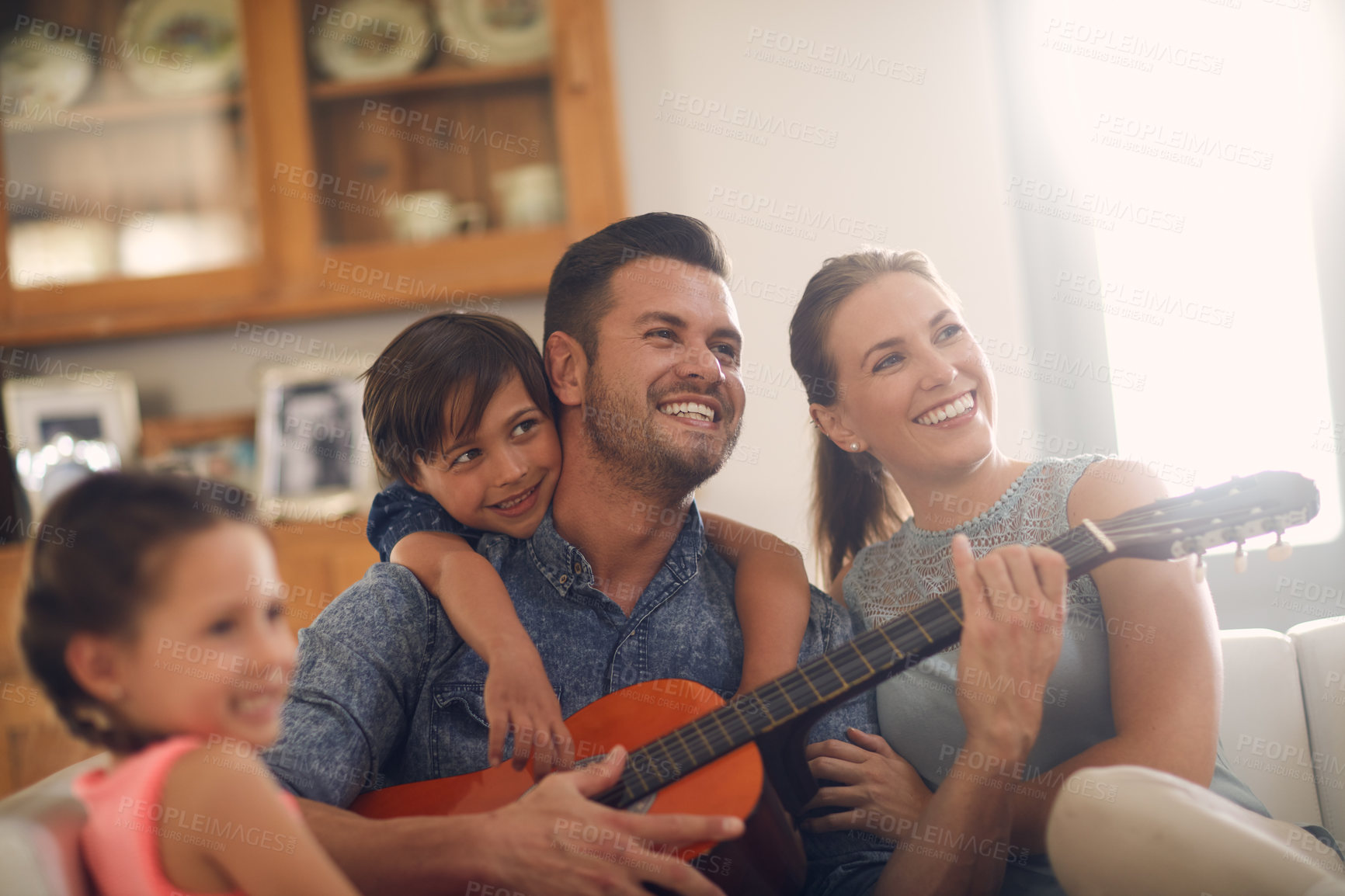 Buy stock photo Shot of a happy father playing the guitar for his family