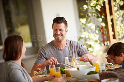Buy stock photo Cropped shot of a family of three sitting down for a meal at home