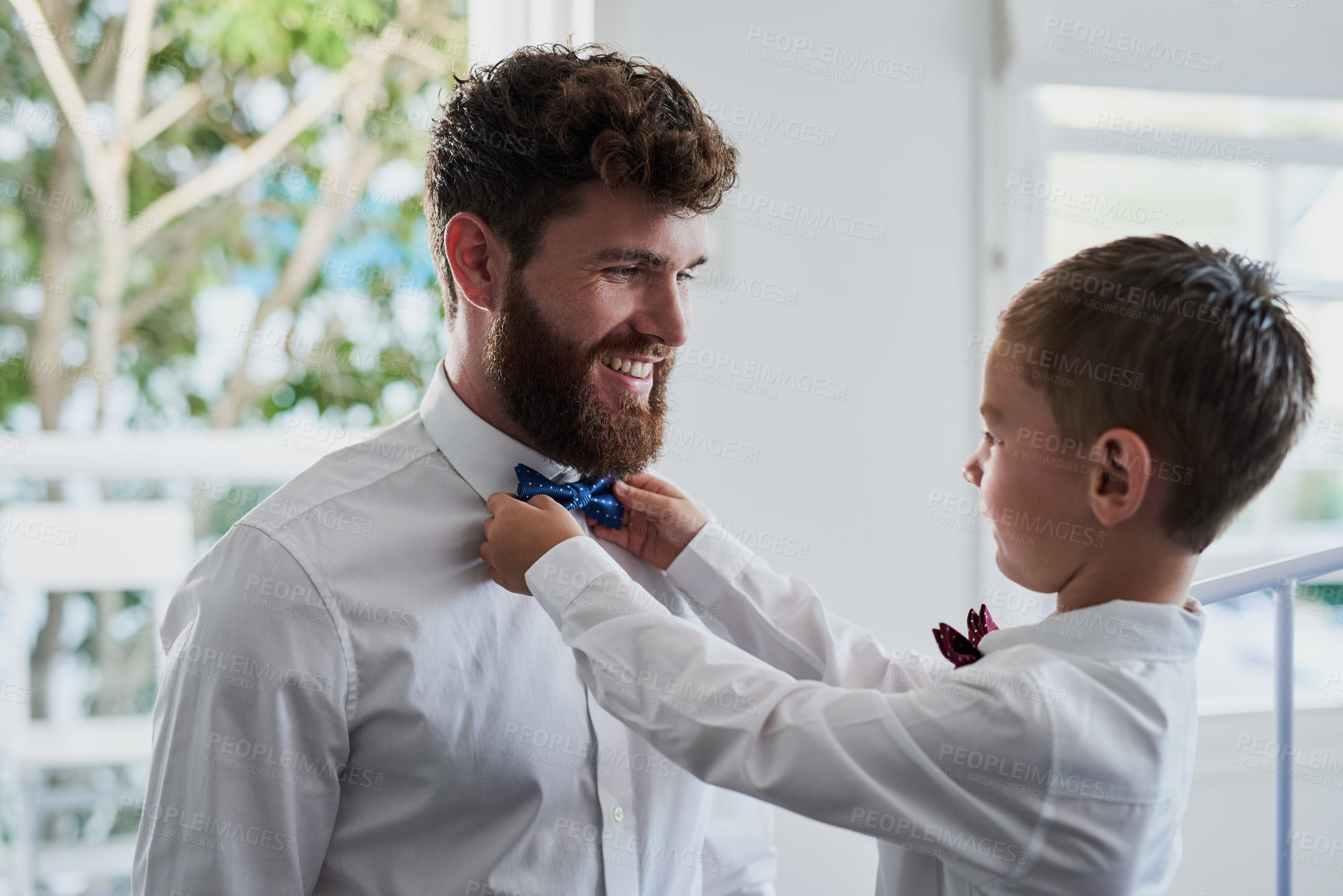 Buy stock photo Cropped shot of an adorable little boy helping his father with his bowtie at home