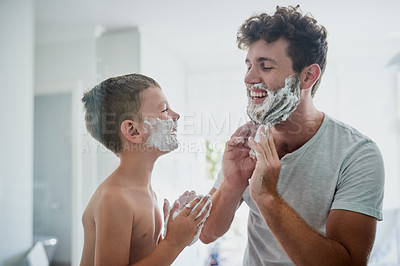 Buy stock photo Kid, father and learning to shave, funny or bonding together in home bathroom. Laughing, dad and teaching child with shaving cream on face beard, playing or cleaning, hygiene or enjoying hair removal