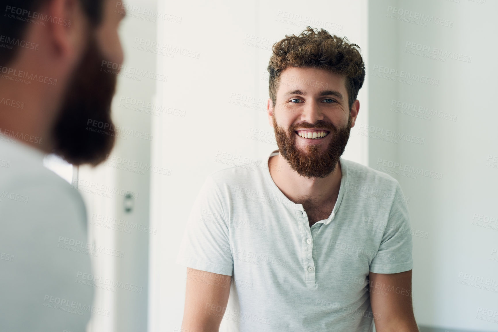 Buy stock photo Cropped shot of a handsome young man looking in the bathroom mirror