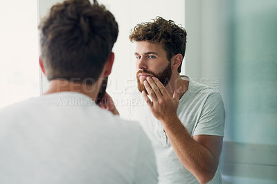 Buy stock photo Skincare, beauty and beard with a man in the bathroom of his home in the morning for fresh hygiene. Mirror, reflection and self care with a handsome young male person checking his face or skin
