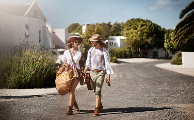 Buy stock photo Shot of an affectionate young couple walking through a residential area