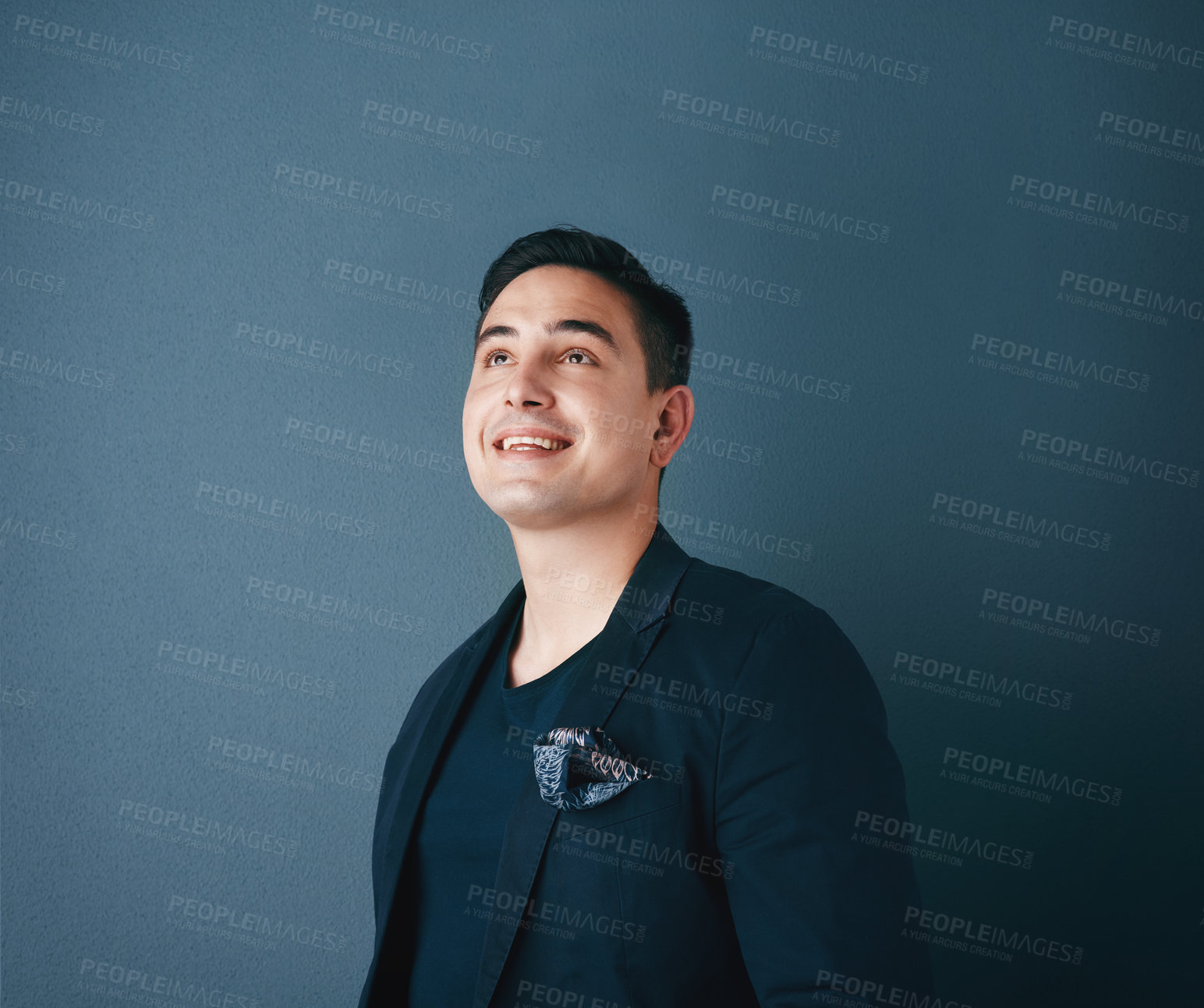 Buy stock photo Studio shot of a handsome young man posing against a blue background