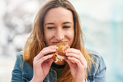 Buy stock photo Portrait of a beautiful young woman eating a sandwich at an amusement park outside