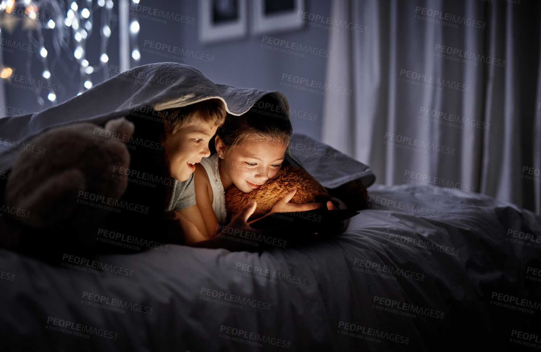 Buy stock photo Night, bedroom and siblings with a tablet, online games and bonding with fun, happiness and relax. Children, brother or sister with technology, movies and films with development, home and bed time