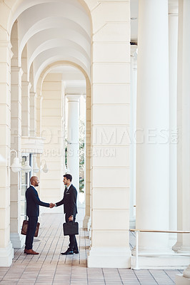 Buy stock photo Shot of two businessmen shaking hands in the city