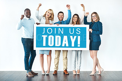 Buy stock photo Studio shot of businesspeople holding up a sign with the words “join us today” on it and cheering