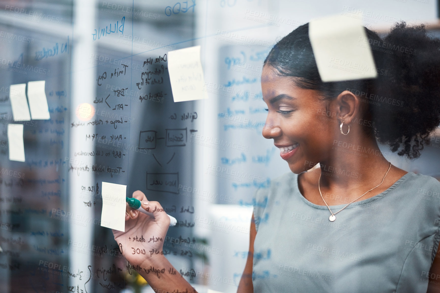 Buy stock photo Happy, inspired and confident business woman brainstorming ideas, writing on transparent glass board with sticky notes. Powerful entrepreneur and CEO leading startup, planning company strategy.