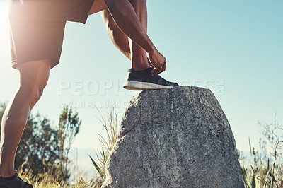 Buy stock photo Runner, legs and tying laces on rock, outdoors and prepare for cardio and marathon training. Man, stone and shoes for exercise or sports in nature, getting ready and feet for workout or athlete
