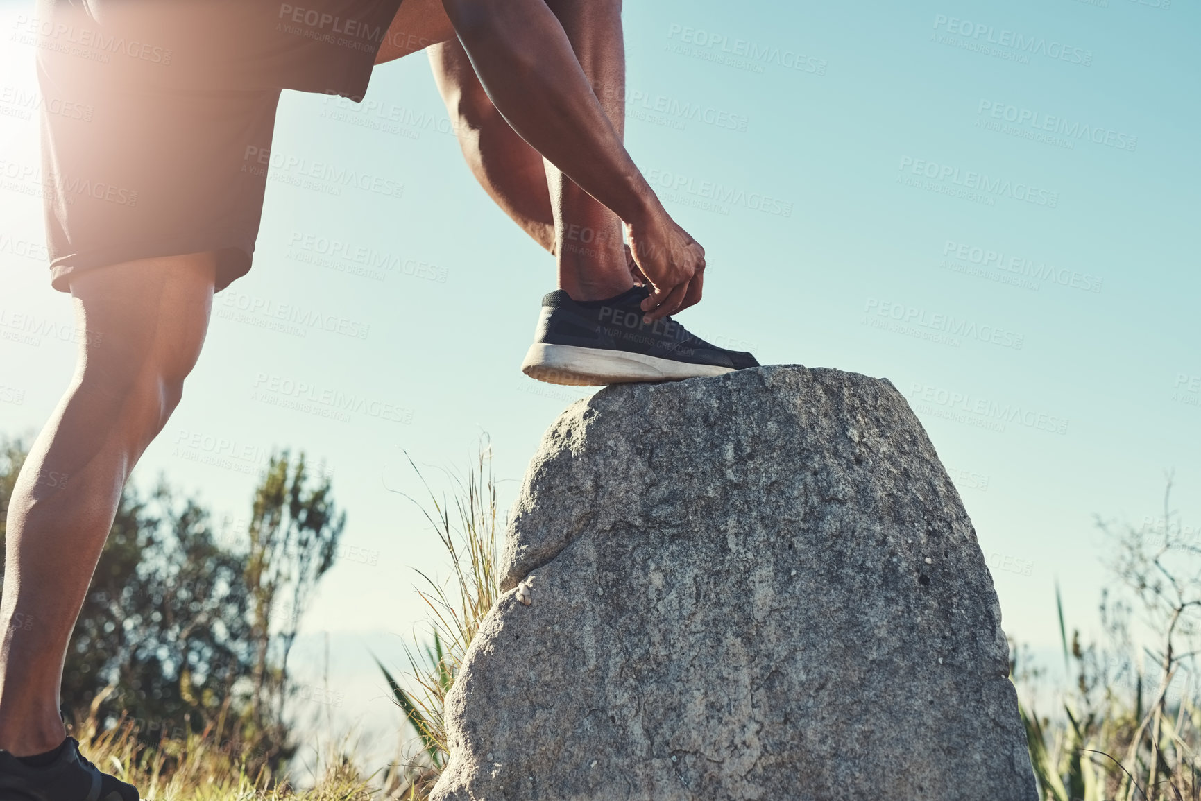 Buy stock photo Runner, legs and tying laces on rock, outdoors and prepare for cardio and marathon training. Man, stone and shoes for exercise or sports in nature, getting ready and feet for workout or athlete