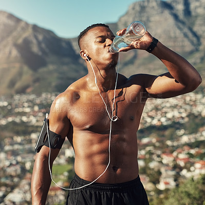 Buy stock photo Black man, shirtless and drink water in outdoors for running, thirst and hydrate on sport break. Person, mountain and mineral liquid in bottle for nutrition, music and phone app for streaming song
