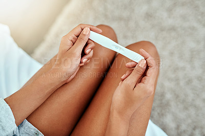 Buy stock photo Cropped shot of a young woman taking a home pregnancy test