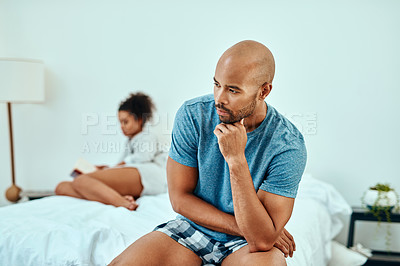 Buy stock photo Shot of a young couple sitting apart after having an argument