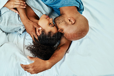 Buy stock photo Cuddle, kiss and couple in bed in morning for bonding, relationship and love in home. Marriage, top view and man and woman in bedroom embrace for comfort, resting and affection for trust and care