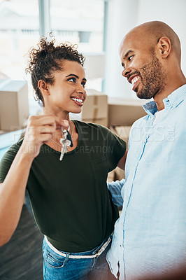 Buy stock photo Shot of a young couple holding the keys to their new home