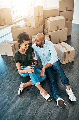 Buy stock photo Shot of a young couple taking a break while moving house