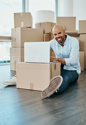 Buy stock photo Portrait of a young man using a laptop while moving house