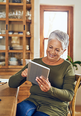 Buy stock photo Shot of a mature woman using a digital tablet at home
