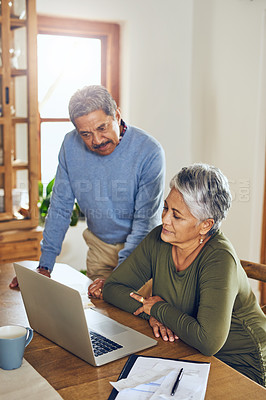 Buy stock photo Shot of a mature couple managing their paperwork together at home