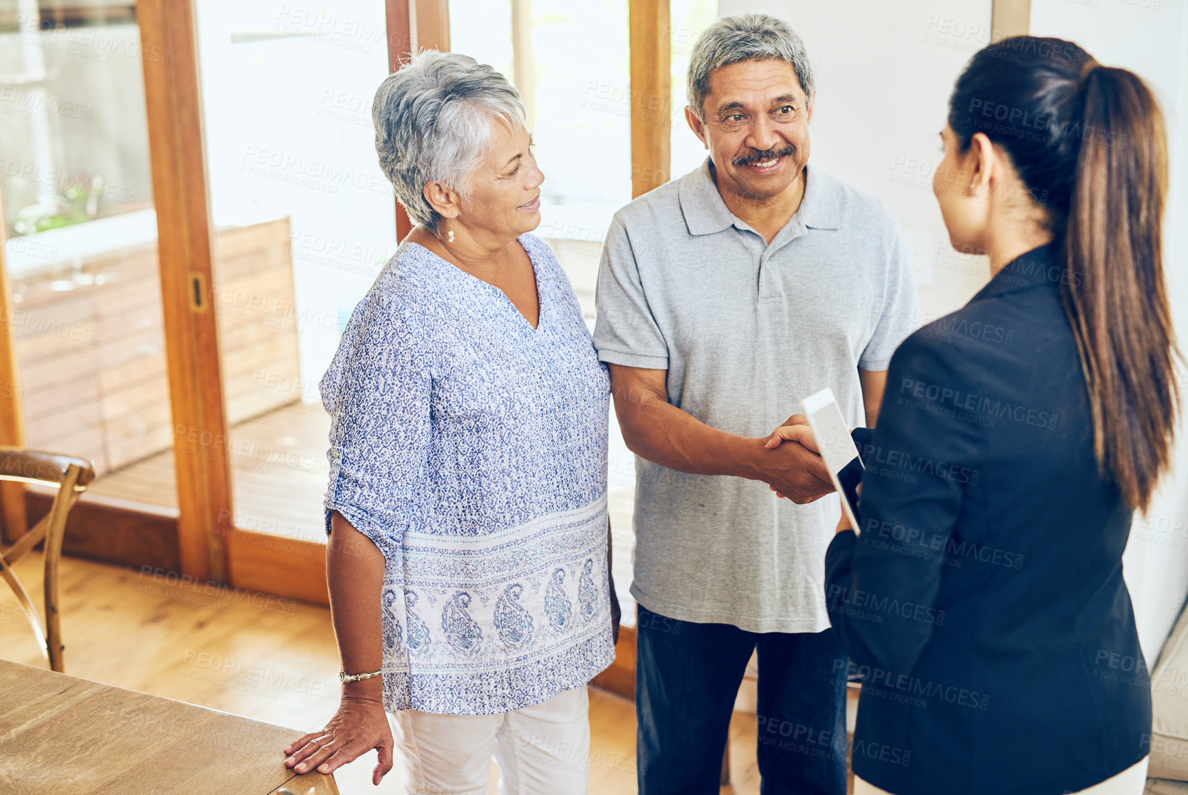 Buy stock photo Shot of a mature couple meeting with their financial consultant at home