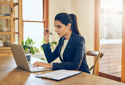 Buy stock photo Shot of a young businesswoman working on a laptop in her home office