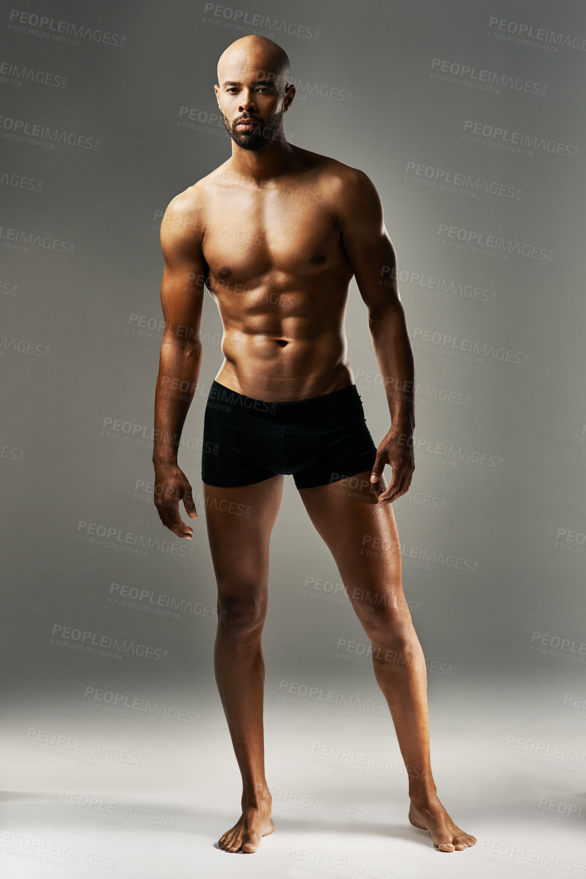 Buy stock photo Studio portrait of a sexy young man against a gray background in his underwear