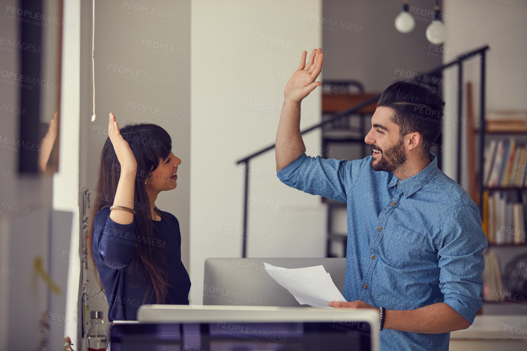 Buy stock photo Shot of a young businessman and businesswoman giving each other a high five in a modern office