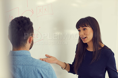 Buy stock photo Shot of a young businessman and businesswoman having a discussion in a modern office