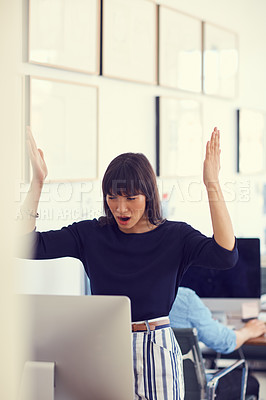 Buy stock photo Shot of a young businesswoman using a computer and looking stressed out at her desk in a modern office