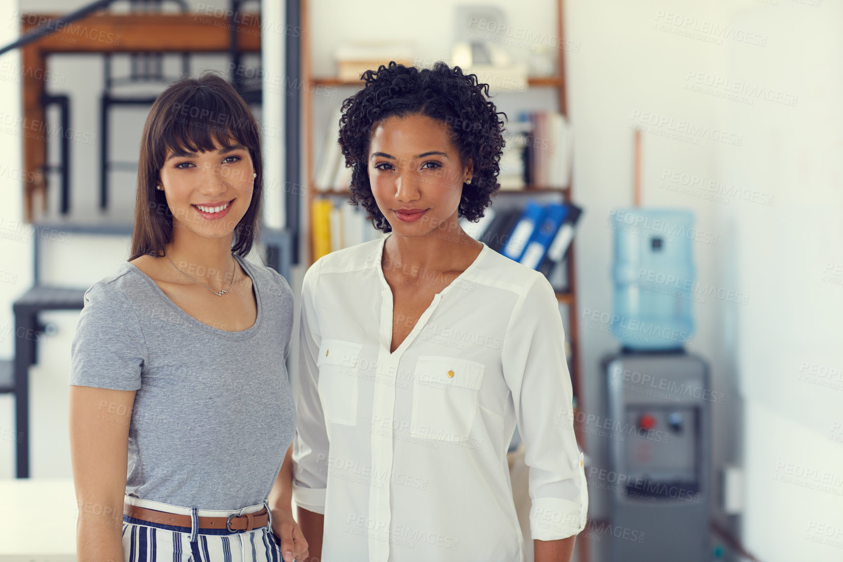 Buy stock photo Portrait of two confident young businesswomen working together in a modern office