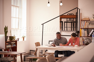 Buy stock photo Shot of a young businessman and businesswoman discussing paperwork in a modern office