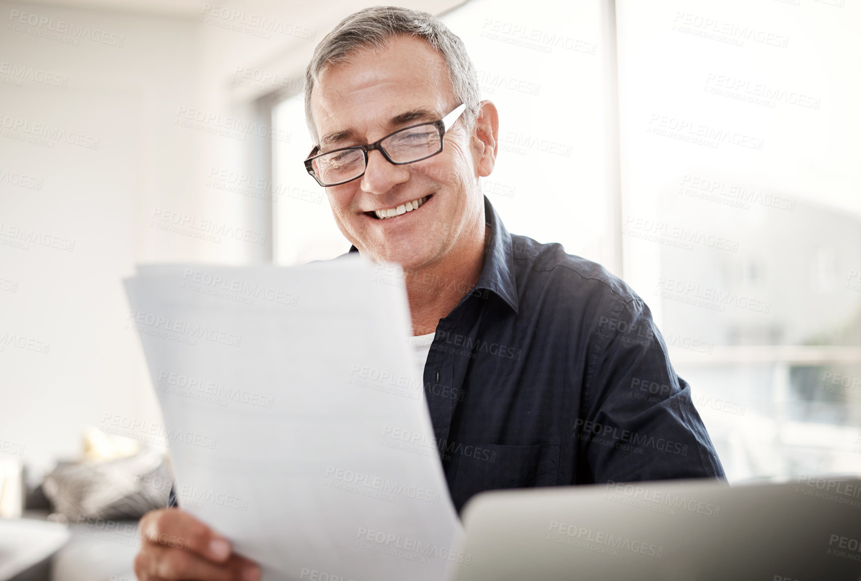 Buy stock photo Shot of a mature man going through some paperwork at home