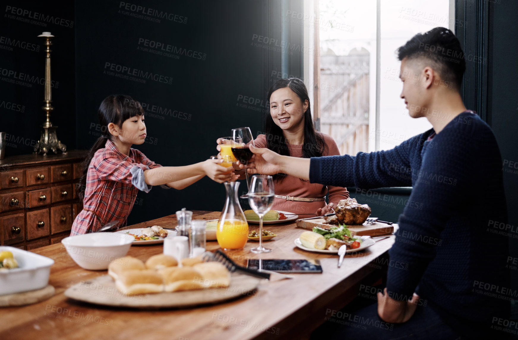 Buy stock photo Shot of a young family having a meal together at home