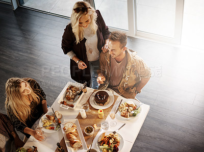 Buy stock photo High angle shot of friends getting together for a dinner party