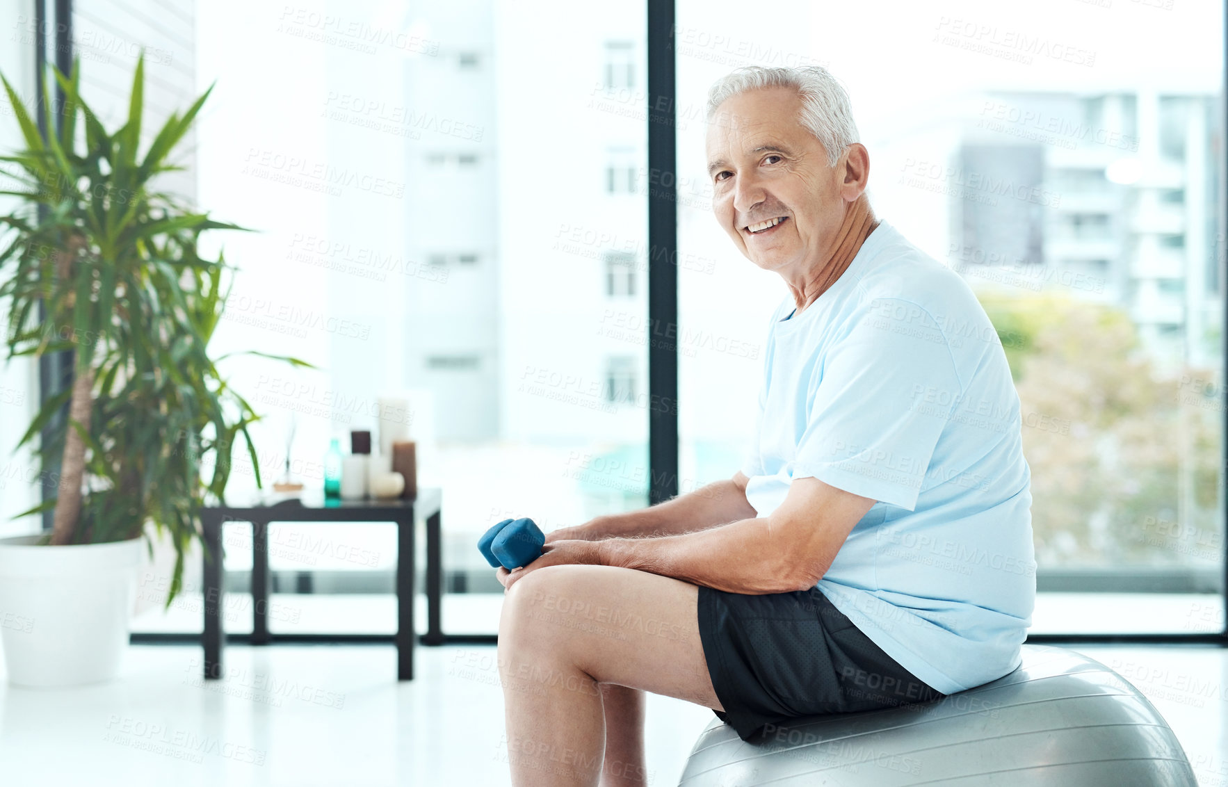 Buy stock photo Shot of a senior man working out with dumbbells