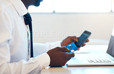 Buy stock photo Closeup of an unrecognizable businessman doing online banking while making use of his cellphone and credit card in the office at work during the day