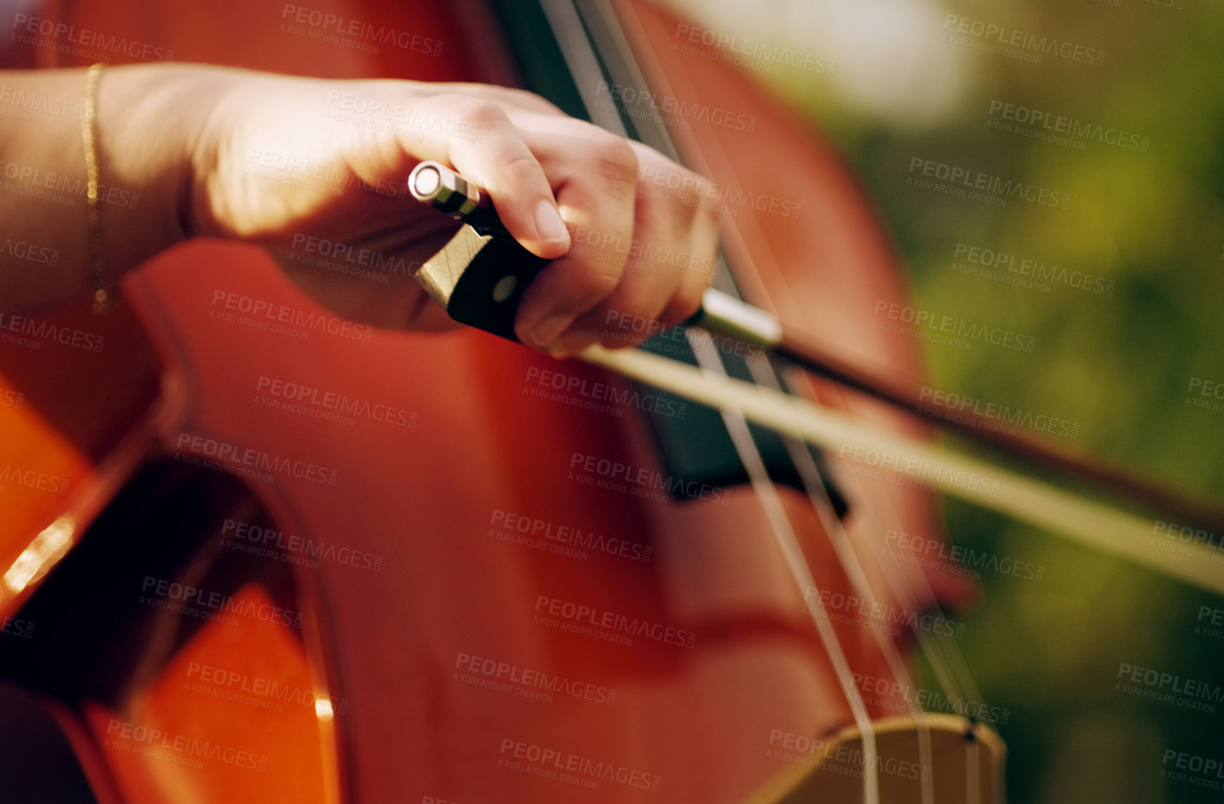 Buy stock photo Cropped shot of an unrecognizable woman playing a cello in the backyard