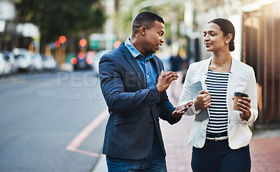 Buy stock photo Shot of two businesspeople having a discussion while walking in the city