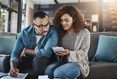 Buy stock photo Shot of a young couple planning their budget together at home