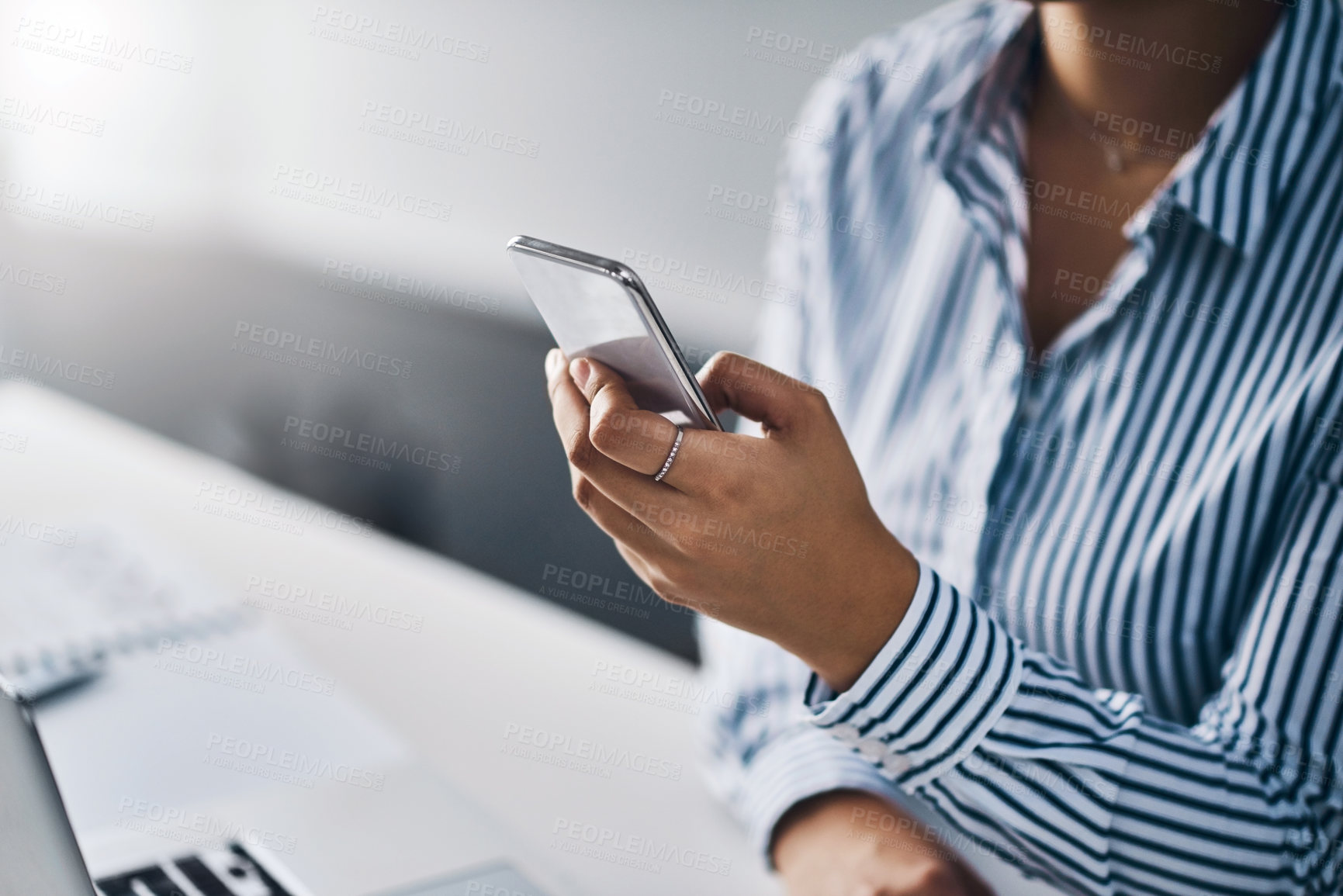 Buy stock photo Closeup shot of an unrecognizable businesswoman using a cellphone in an office