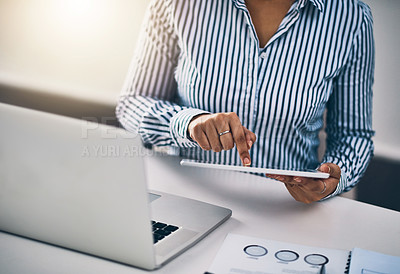 Buy stock photo Closeup shot of an unrecognizable businesswoman working on a digital tablet in an office
