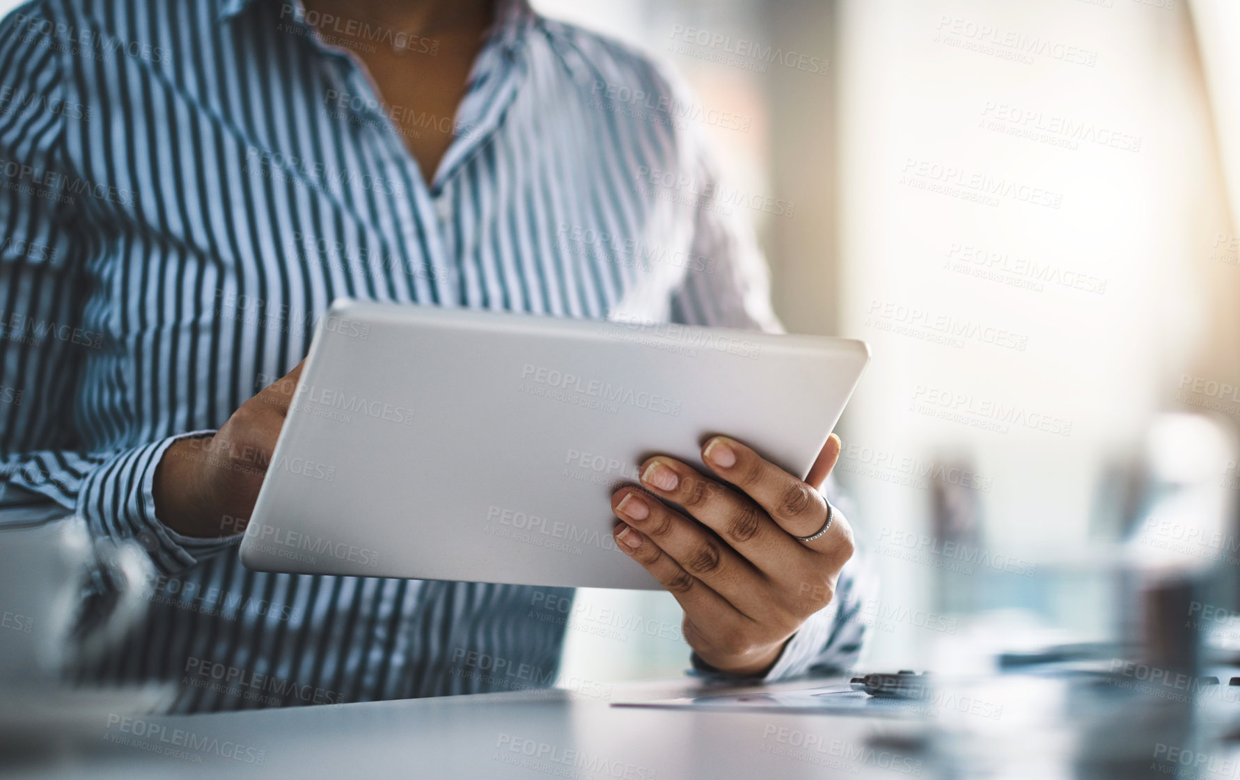 Buy stock photo Closeup shot of an unrecognizable businesswoman working on a digital tablet in an office